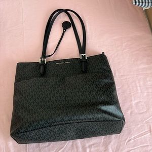 Michael Kors black tote bag with silver metal zippers.